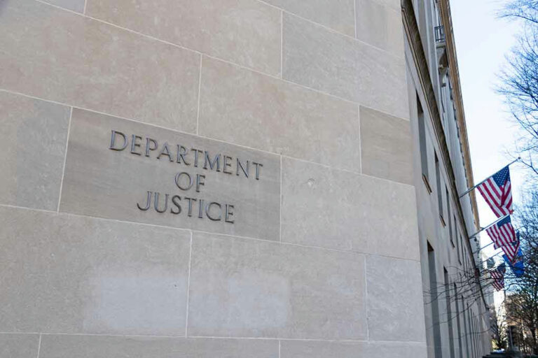 Department of Justice building with American flags outside.