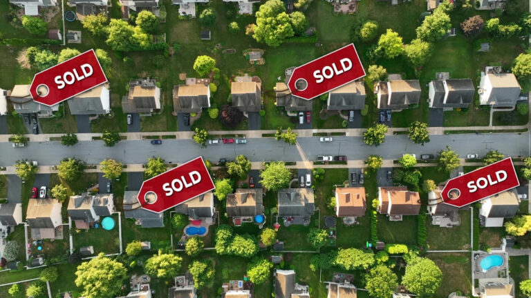 Aerial view of neighborhood with Sold signs on houses.