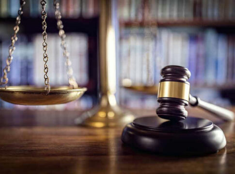 Scales of justice and gavel in courtroom.